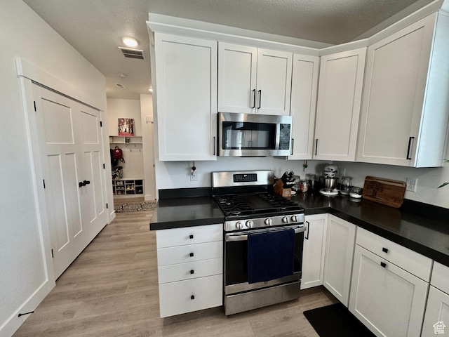 1038 W 980 S Unit 312, American Fork, UT 84003 - kitchen featuring appliances with stainless steel finishes, dark countertops, and white cabinets