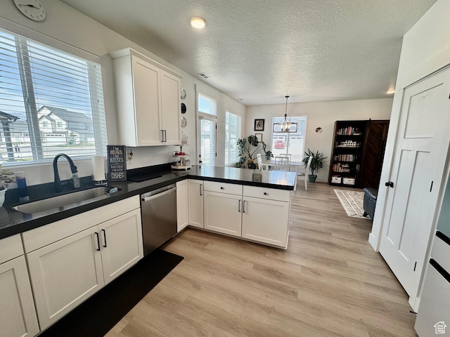 1038 W 980 S Unit 312, American Fork, UT 84003 - kitchen featuring dishwasher, light wood-style floors, white cabinetry, a peninsula, and a textured ceiling