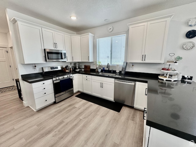 1038 W 980 S Unit 312, American Fork, UT 84003 - kitchen with appliances with stainless steel finishes, white cabinetry, dark countertops, and a textured ceiling