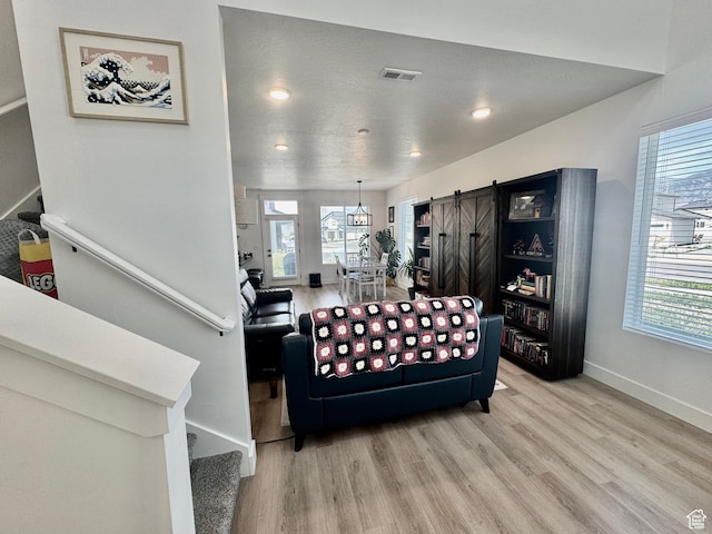 1038 W 980 S Unit 312, American Fork, UT 84003 - living area with stairway, light wood finished floors, a barn door, healthy amount of natural light, and recessed lighting