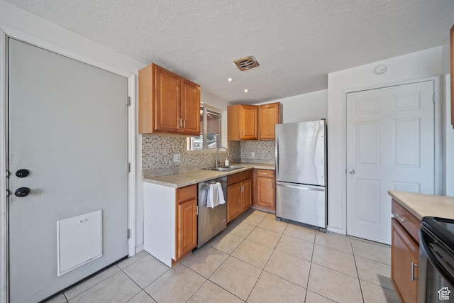 5154 S Lori Way, Salt Lake City, UT 84117 - kitchen with appliances with stainless steel finishes, light countertops, decorative backsplash, light tile patterned floors, and brown cabinetry