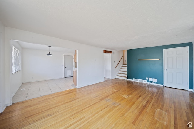 5154 S Lori Way, Salt Lake City, UT 84117 - unfurnished room with stairway, wood-type flooring, and a textured ceiling