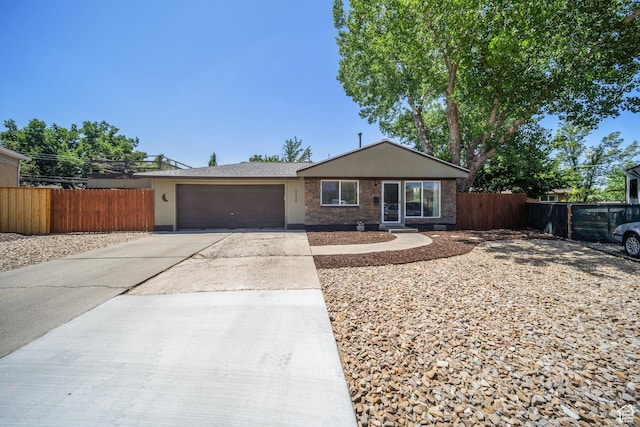 5154 S Lori Way, Salt Lake City, UT 84117 - view of front of property with an attached garage, concrete driveway, and stone siding
