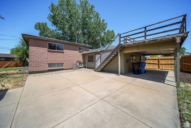 5154 S Lori Way, Salt Lake City, UT 84117 - rear view of house featuring stairs, concrete driveway, and a carport