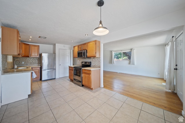 5154 S Lori Way, Salt Lake City, UT 84117 - kitchen with appliances with stainless steel finishes, light tile patterned floors, tasteful backsplash, light countertops, and decorative light fixtures