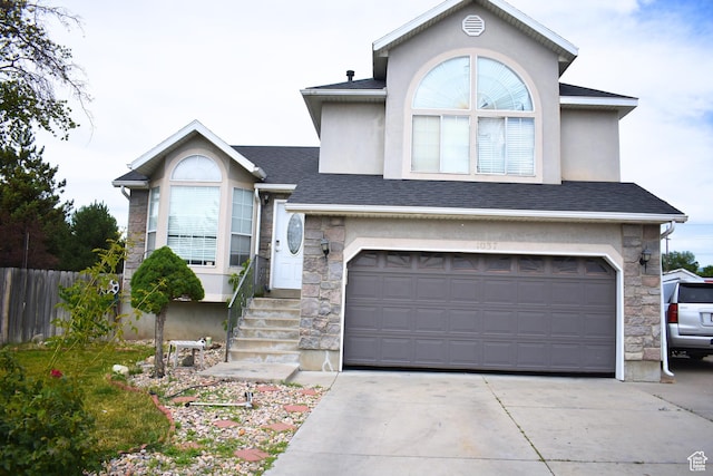 1037 W State Cir, Salt Lake City, UT 84104 - view of front of house featuring stone siding, concrete driveway, an attached garage, and stucco siding
