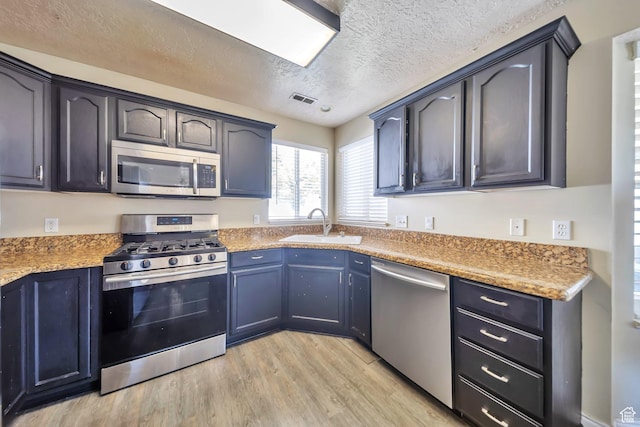 637 W Chase Ln, Centerville, UT 84014 - kitchen featuring appliances with stainless steel finishes, light wood finished floors, a textured ceiling, and light countertops