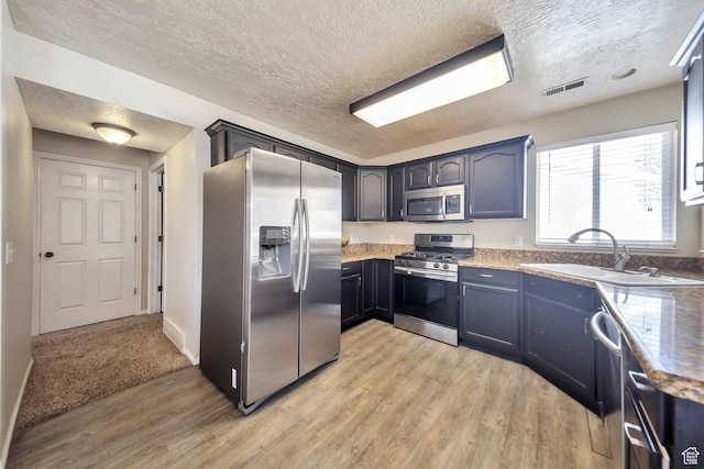 637 W Chase Ln, Centerville, UT 84014 - kitchen with stainless steel appliances, light wood-style floors, and a textured ceiling