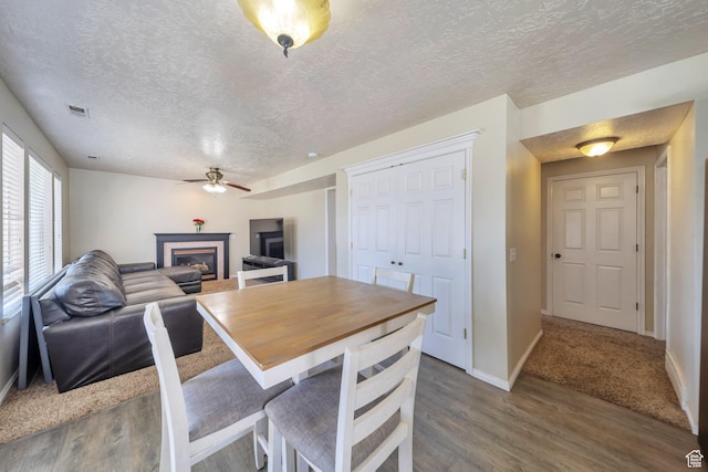 637 W Chase Ln, Centerville, UT 84014 - dining area featuring ceiling fan, a glass covered fireplace, wood finished floors, and a textured ceiling