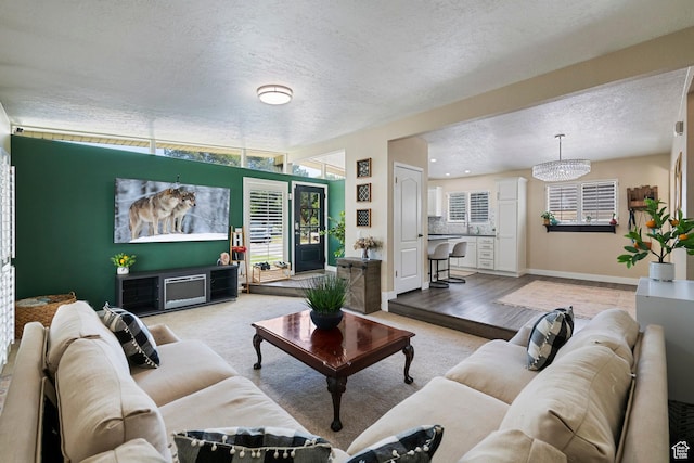 6764 S Enchanted Dr E, Midvale, UT 84047 - carpeted living area with a textured ceiling and a chandelier