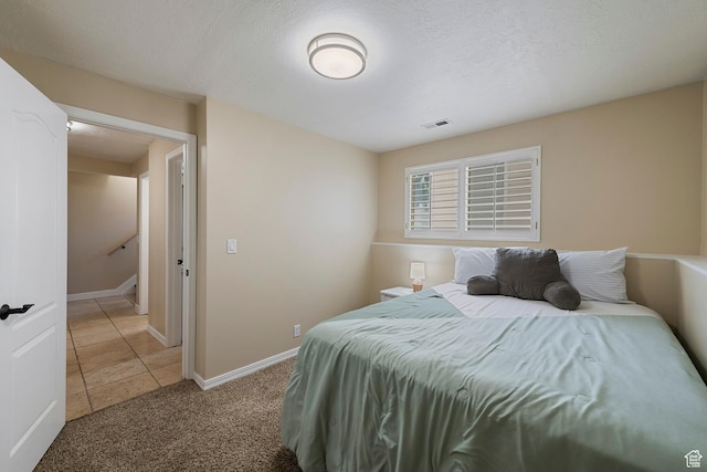6764 S Enchanted Dr E, Midvale, UT 84047 - bedroom featuring light colored carpet, light tile patterned floors, and a textured ceiling