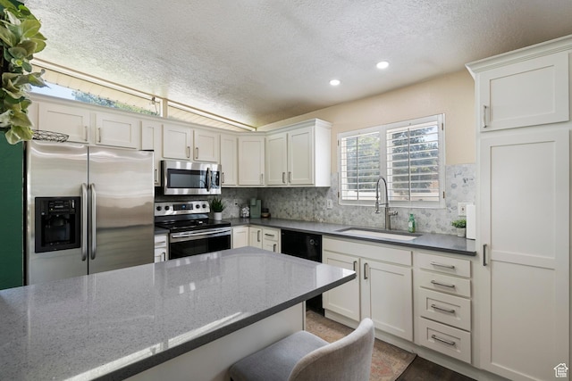 6764 S Enchanted Dr E, Midvale, UT 84047 - kitchen featuring stainless steel appliances, a textured ceiling, tasteful backsplash, white cabinets, and recessed lighting