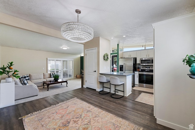 6764 S Enchanted Dr E, Midvale, UT 84047 - living area featuring dark wood-style flooring, a chandelier, a textured ceiling, and recessed lighting