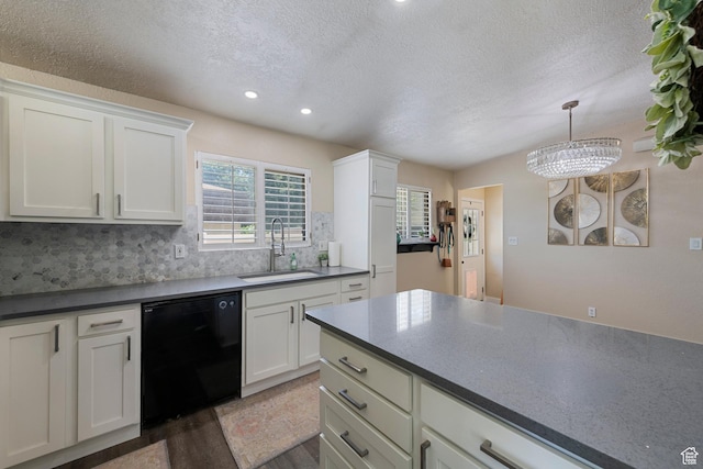 6764 S Enchanted Dr E, Midvale, UT 84047 - kitchen featuring black dishwasher, a textured ceiling, wood finished floors, tasteful backsplash, and white cabinetry