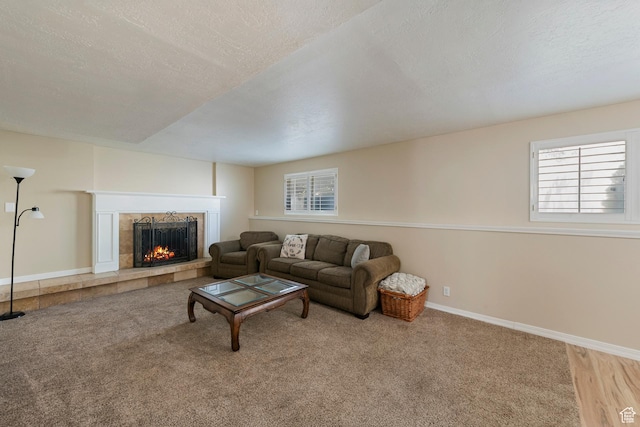 6764 S Enchanted Dr E, Midvale, UT 84047 - living area featuring a tiled fireplace, healthy amount of natural light, a textured ceiling, and carpet floors