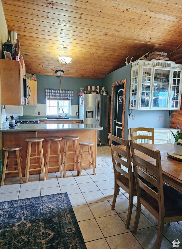 268 W Peach St, Grantsville, UT 84029 - kitchen with appliances with stainless steel finishes, wooden ceiling, light tile patterned floors, a peninsula, and a kitchen breakfast bar