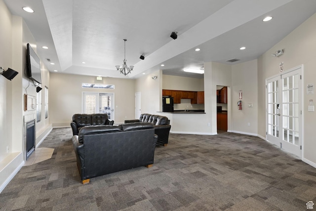 13574 S Cantania Way, Draper, UT 84020 - living room featuring dark carpet, recessed lighting, a tray ceiling, a chandelier, and a fireplace with flush hearth