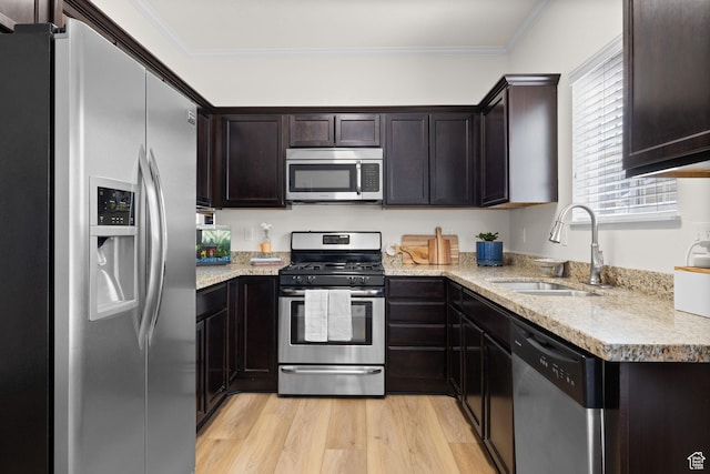 13574 S Cantania Way, Draper, UT 84020 - kitchen with appliances with stainless steel finishes, light wood-style floors, dark brown cabinetry, crown molding, and light stone counters