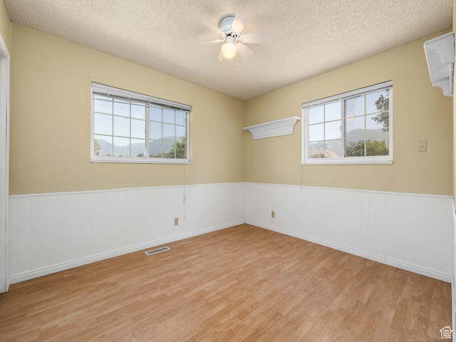 550 S 700 W, Payson, UT 84651 - spare room with light wood-style floors, plenty of natural light, a textured ceiling, wainscoting, and a ceiling fan