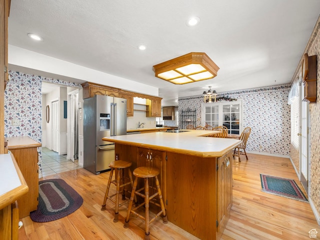 550 S 700 W, Payson, UT 84651 - kitchen with high end fridge, wallpapered walls, light wood finished floors, a kitchen island, and light countertops