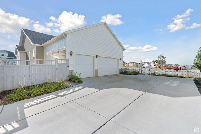 11449 S Bingham Rim Rd, South Jordan, UT 84009 - view of home's exterior with driveway, a gate, a residential view, and a garage