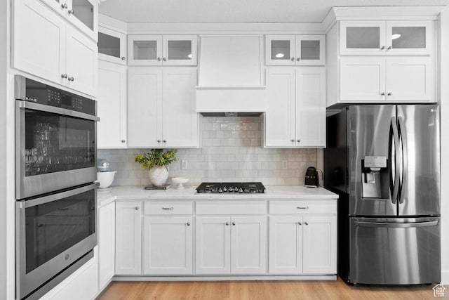 11449 S Bingham Rim Rd, South Jordan, UT 84009 - kitchen featuring stainless steel appliances, white cabinets, tasteful backsplash, and light wood-type flooring