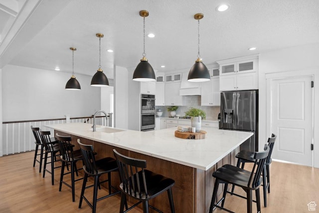 11449 S Bingham Rim Rd, South Jordan, UT 84009 - kitchen with stainless steel appliances, light wood-style floors, a large island, white cabinetry, and recessed lighting