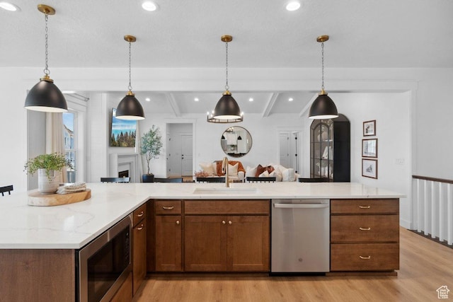11449 S Bingham Rim Rd, South Jordan, UT 84009 - kitchen featuring appliances with stainless steel finishes, light wood-style flooring, decorative light fixtures, light stone counters, and recessed lighting