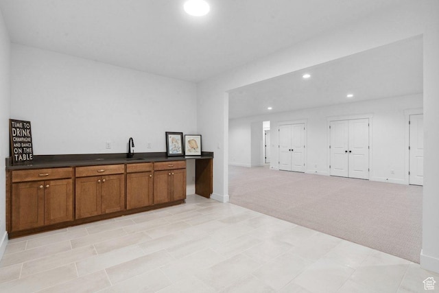 11449 S Bingham Rim Rd, South Jordan, UT 84009 - kitchen featuring brown cabinetry, dark countertops, light carpet, recessed lighting, and open floor plan