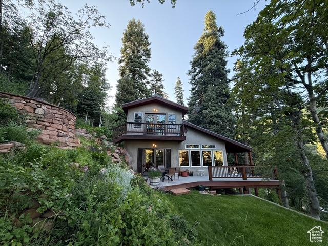 2137 N Pinecrest Canyon Rd Unit 35, Emigration Canyon, UT 84108 - back of house featuring a balcony, a wooden deck, a lawn, and stucco siding