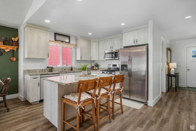 893 N 300 W, Santaquin, UT 84655 - kitchen with stainless steel appliances, wood finished floors, a kitchen bar, light stone countertops, and a kitchen island