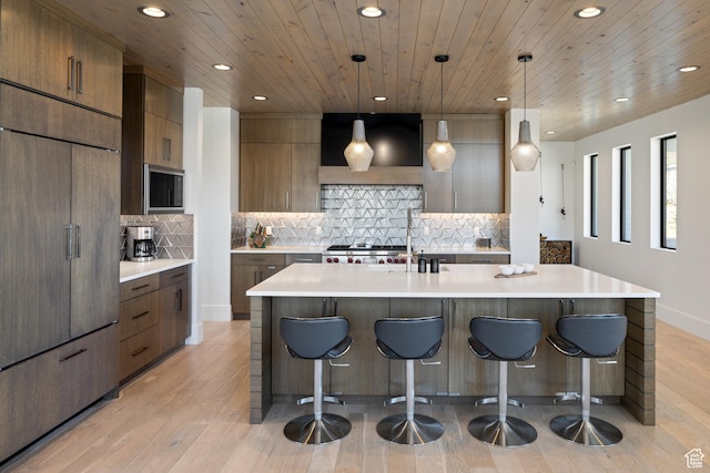 13202 N Alexis Dr, Heber City, UT 84036 - kitchen with built in appliances, range hood, recessed lighting, a breakfast bar area, and modern cabinets