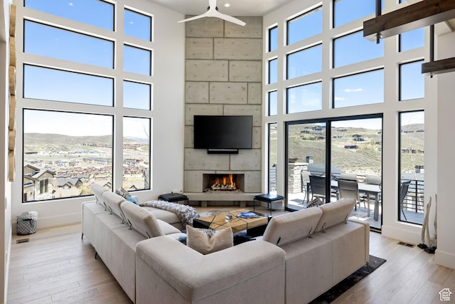 13202 N Alexis Dr, Heber City, UT 84036 - living room featuring a towering ceiling, a lit fireplace, and light wood-style flooring