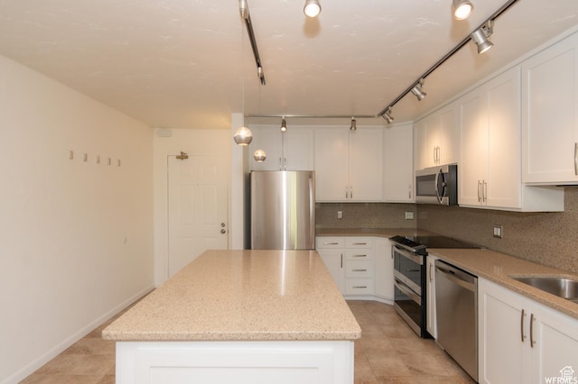 115 S 1100 E, Salt Lake City, UT 84102 - kitchen featuring appliances with stainless steel finishes, a kitchen island, white cabinets, decorative backsplash, and light stone counters
