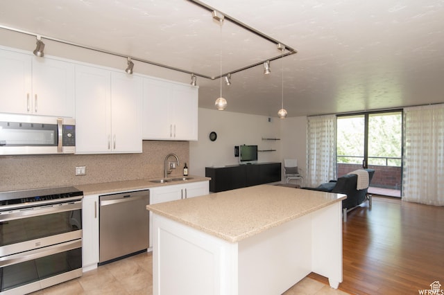 115 S 1100 E, Salt Lake City, UT 84102 - kitchen with stainless steel appliances, rail lighting, open floor plan, white cabinetry, and a center island