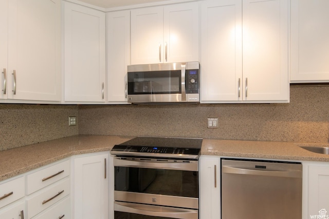 115 S 1100 E, Salt Lake City, UT 84102 - kitchen featuring stainless steel appliances, white cabinets, decorative backsplash, and light stone counters
