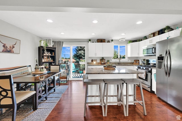 604 W 1750 N, Clinton, UT 84015 - kitchen with appliances with stainless steel finishes, healthy amount of natural light, a kitchen bar, stone countertops, and recessed lighting