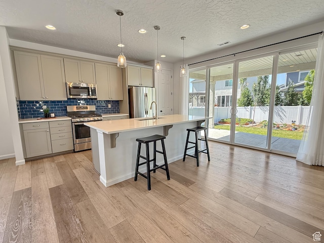 998 W 850 S, Springville, UT 84663 - kitchen with appliances with stainless steel finishes, gray cabinets, light countertops, light wood-style floors, and a center island with sink