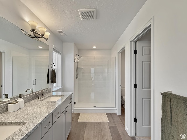 998 W 850 S, Springville, UT 84663 - bathroom featuring wood finished floors, a stall shower, double vanity, a textured ceiling, and recessed lighting
