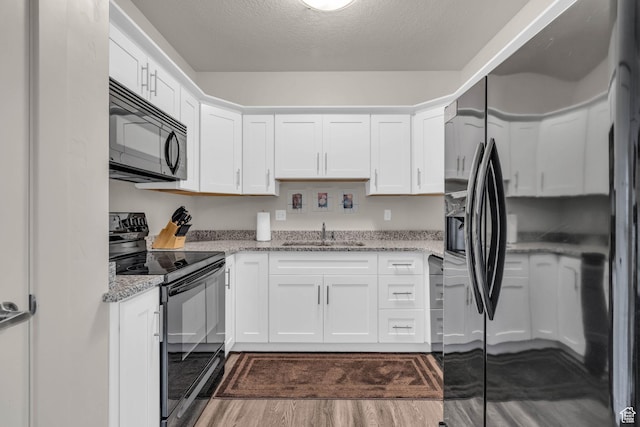 1043 S 500 E Unit G304, Heber City, UT 84032 - kitchen featuring black appliances, dark wood-style floors, white cabinetry, light stone countertops, and a textured ceiling