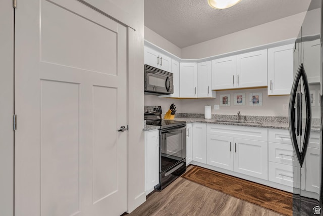 1043 S 500 E Unit G304, Heber City, UT 84032 - kitchen featuring black appliances, dark wood-style flooring, a textured ceiling, white cabinets, and light stone counters