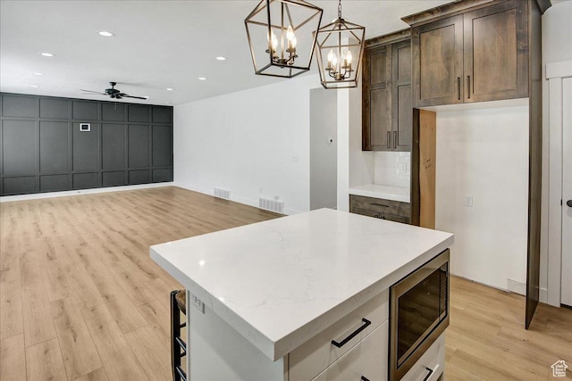 1978 N 840 E, North Ogden, UT 84414 - kitchen featuring stainless steel microwave, light wood-style flooring, ceiling fan, a chandelier, and a kitchen island