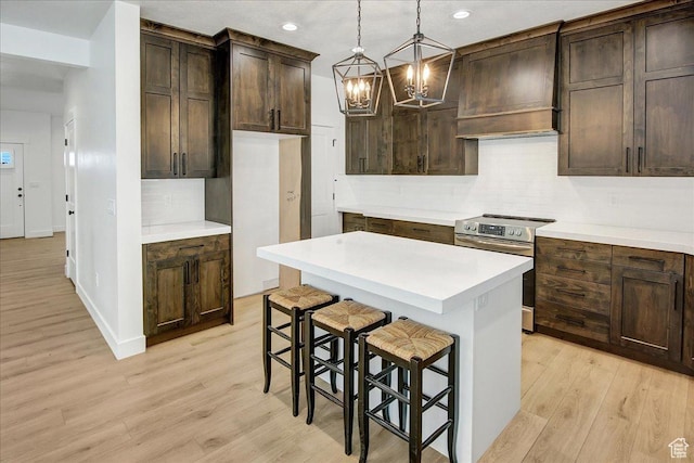 1978 N 840 E, North Ogden, UT 84414 - kitchen featuring stainless steel range with electric cooktop, custom range hood, backsplash, a chandelier, and light wood finished floors