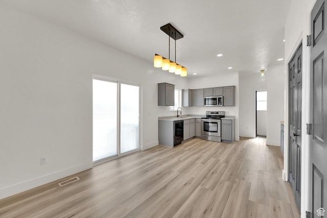 3482 E Kennekuk Cir, Eagle Mountain, UT 84005 - kitchen featuring appliances with stainless steel finishes, gray cabinetry, light countertops, light wood finished floors, and recessed lighting