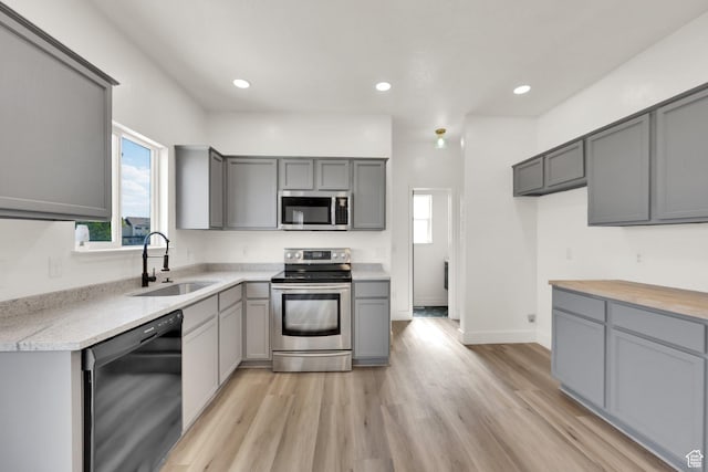 3482 E Kennekuk Cir, Eagle Mountain, UT 84005 - kitchen featuring appliances with stainless steel finishes, gray cabinetry, light wood-style floors, and recessed lighting
