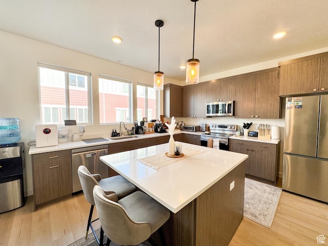 4721 W Talavara Way S, Kearns, UT 84118 - kitchen with stainless steel appliances, light wood-style flooring, light countertops, a center island, and recessed lighting