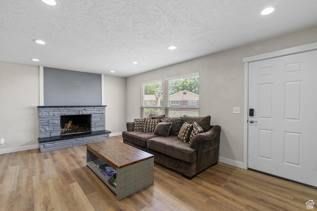 2234 W 300 N, West Point, UT 84015 - living area with a textured ceiling, recessed lighting, wood finished floors, and a stone fireplace