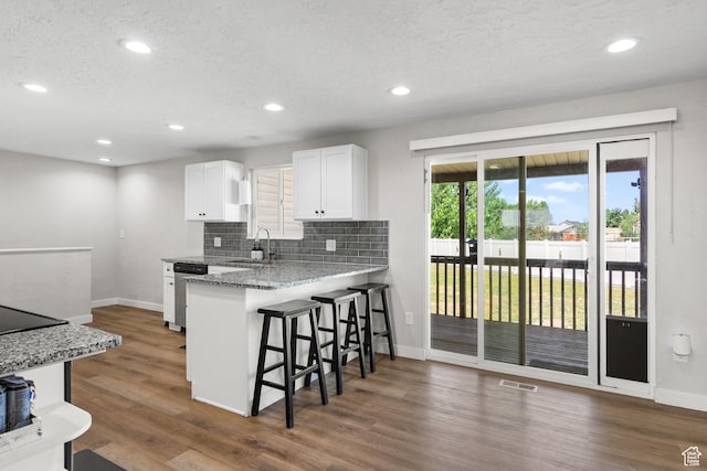 2234 W 300 N, West Point, UT 84015 - kitchen with a kitchen breakfast bar, white cabinets, tasteful backsplash, recessed lighting, and dark wood finished floors