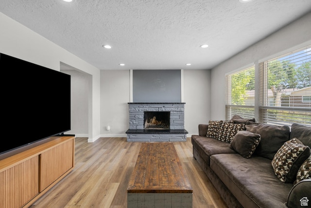 2234 W 300 N, West Point, UT 84015 - living area with recessed lighting, light wood-type flooring, a stone fireplace, and a textured ceiling