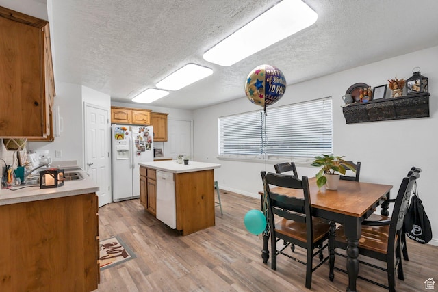 197 E Utah Ave, Payson, UT 84651 - kitchen with white appliances, a textured ceiling, a center island, light wood-style flooring, and light countertops